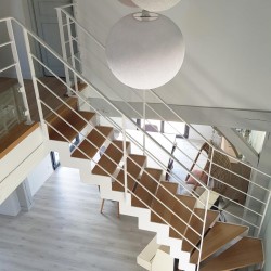 Escalier blanc design à marches en bois et structure métallique