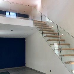 Escalier moderne à marches suspendues en bois et garde-corps en verre